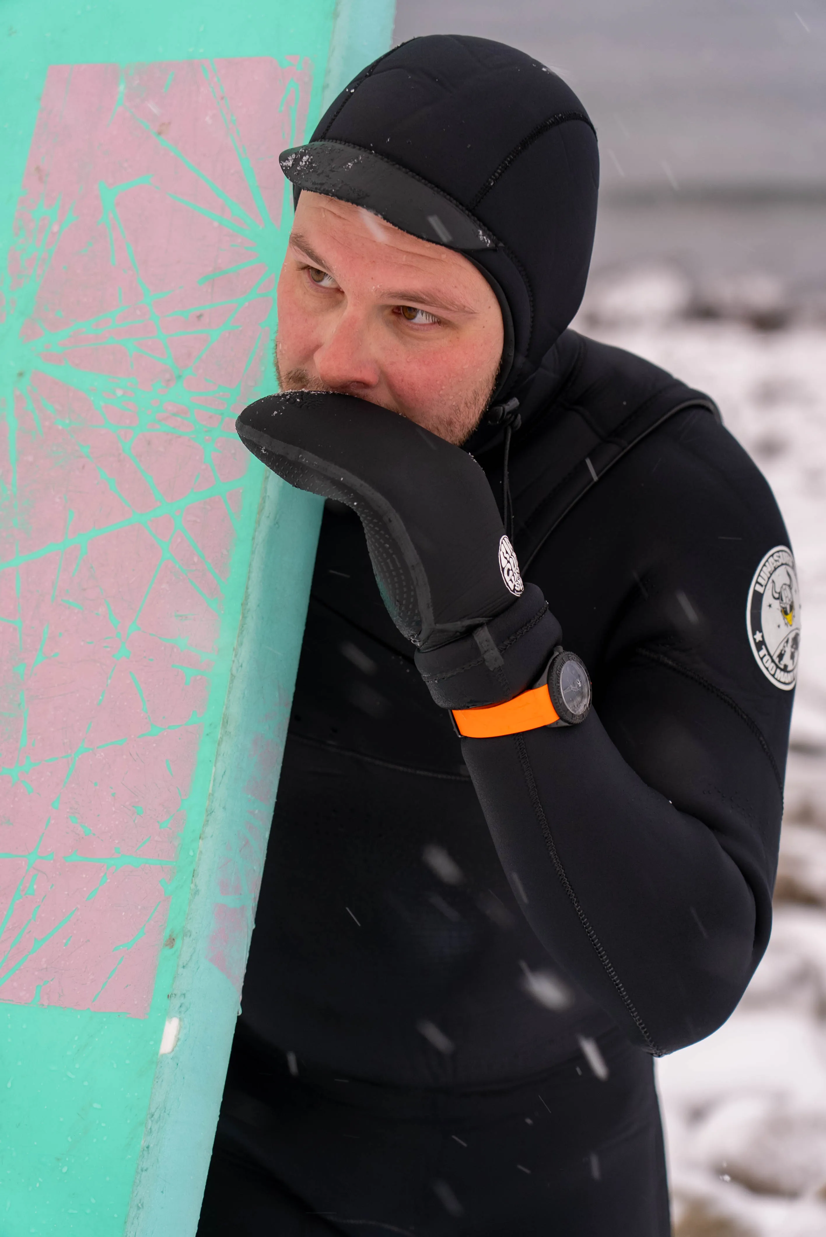 Marvin en combinaison de surf, planche sous le bras, sous la neige